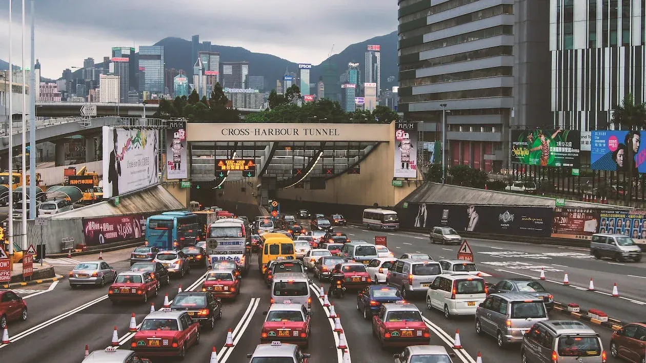 Traffic jam of taxis, buses and cars queued at the entrance of the Cross-Harbour Tunnel, standing in for visitors waiting on a slow site