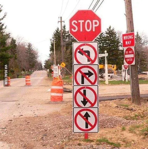 Road sign joke: a stop sign above four signs banning left turns, right turns, going straight and U-turns, leaving no way to go